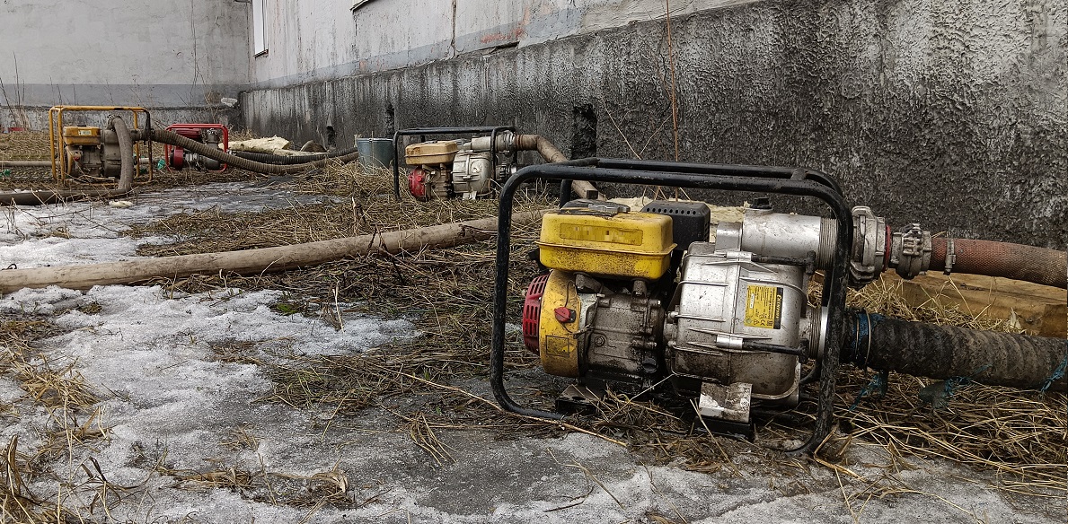 Откачка мотопомпами талой воды из подвала дома в Троицко-Печерске